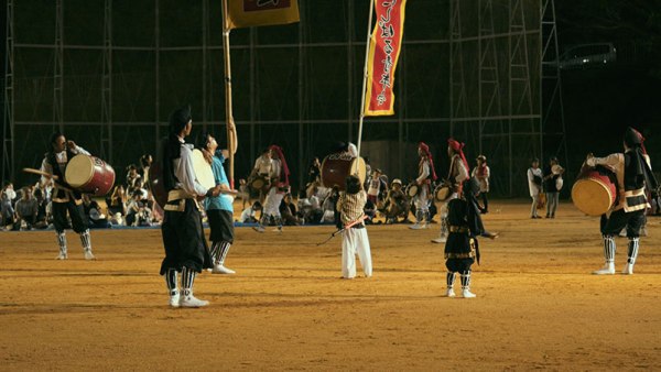 Young male Okinawans drum and dance in circle